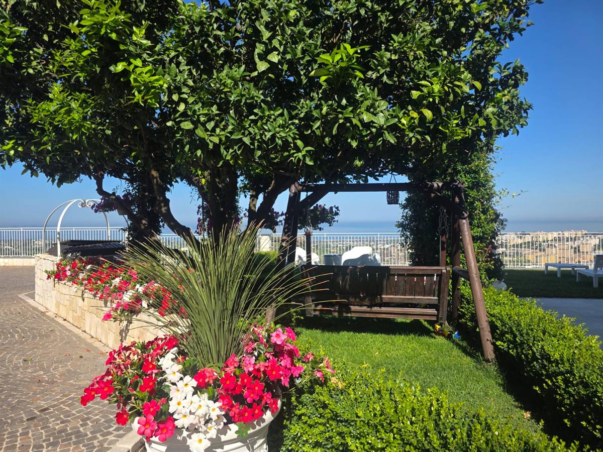 Dondolo sotto l'albero di limoni con fiori e vista sul mare alla Tenuta Sant'Angelo