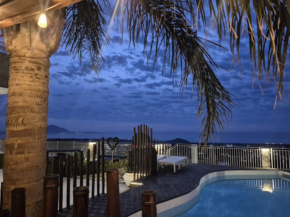 La piscina della Tenuta Sant'Angelo all'ora blu con vista sul Golfo