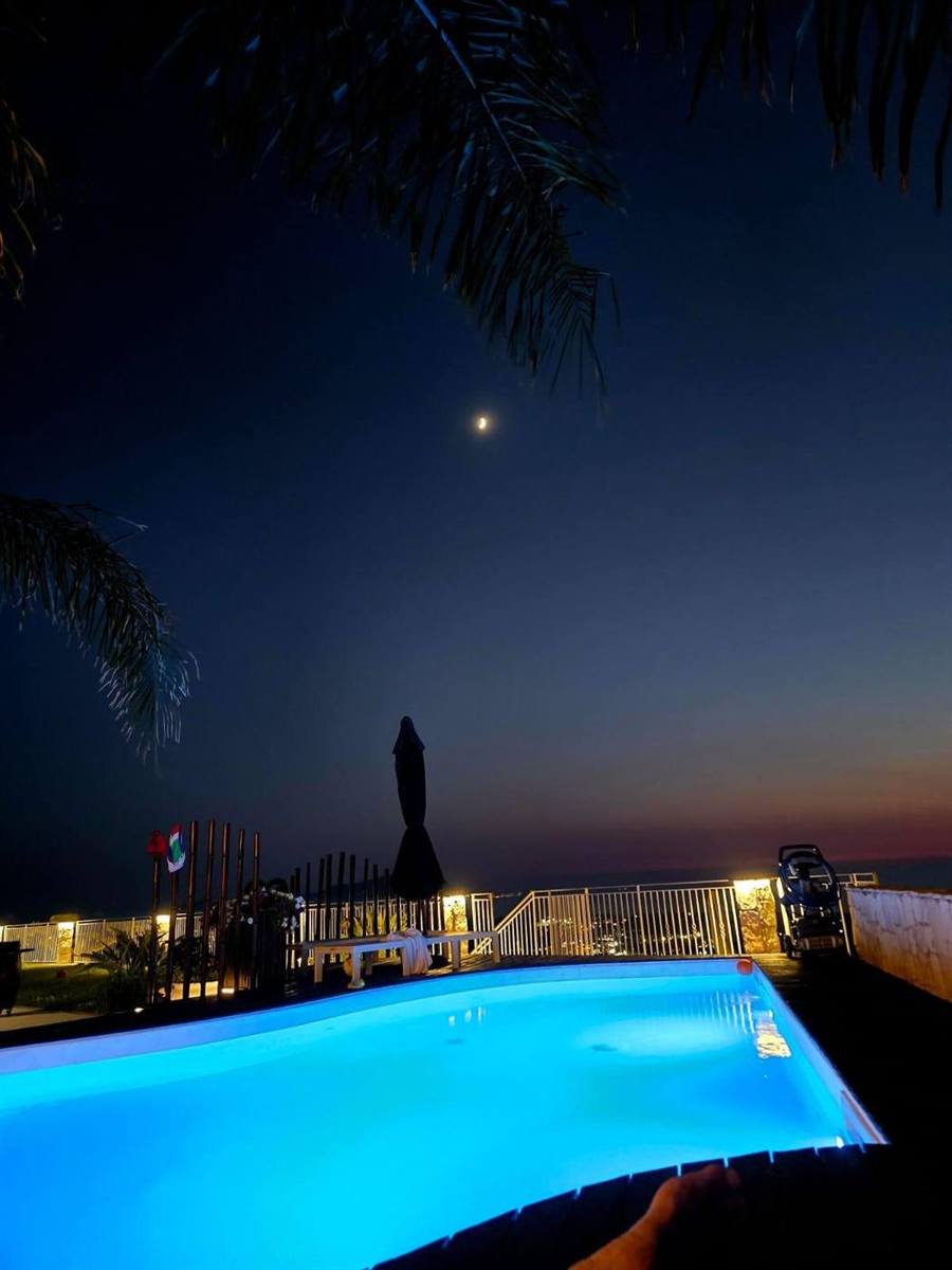 Piscina illuminata di notte sotto la luna